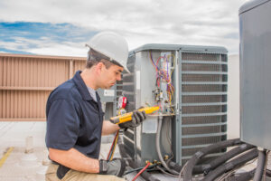 Trained,hvac,technician,holding,a,voltage,meter,,performing,preventative,maintenance