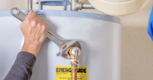 a water heater being repaired with a wrench